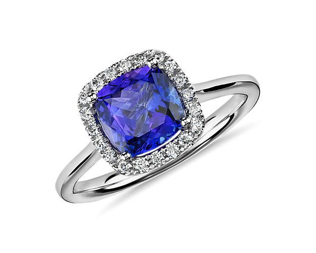 Lively in color, this halo ring features a cushion tanzanite framed by pavé-set round diamonds in 14k white gold.