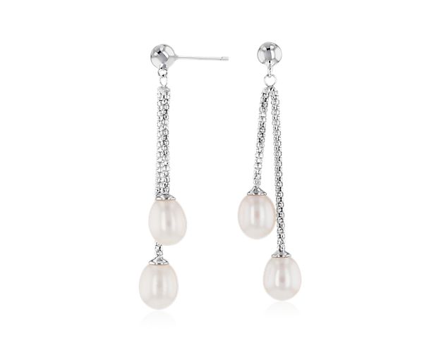 A pair of glossy Freshwater pearls hang from staggered lengths of sterling silver, creating a lustrous, layered look.