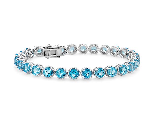 Delicately hued, this blue topaz bracelet is crafted in sterling silver and features twenty-eight lightly-colored, round Swiss blue topaz gemstones in a flexible single line design.