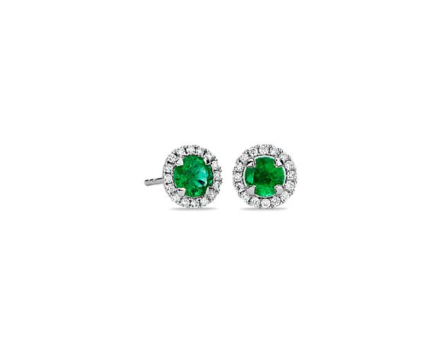 These classic stud earrings boast vibrant emeralds surrounded by a halo of brilliant round diamonds for a smart and sophisticated look.
