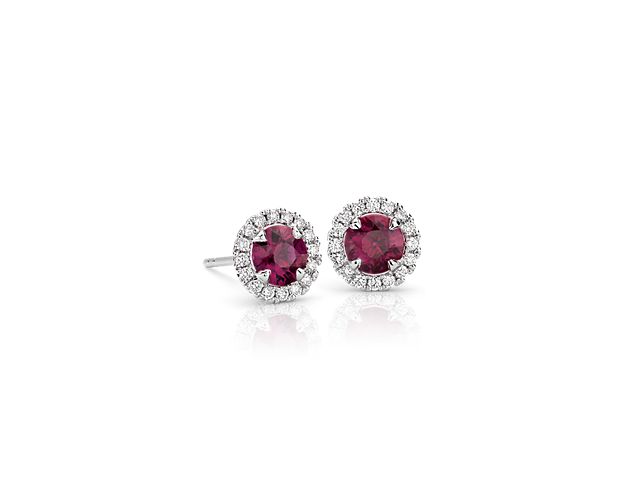 These classic stud earrings boast fiery rubies surrounded by a halo of brilliant round diamonds for a smart and sophisticated look.