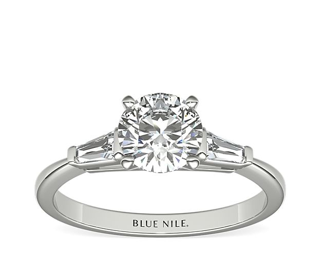 This iconic ring features two tapered baguette-cut diamonds set in classic bar channels, brilliantly framing the center diamond of your choice. Crafted in bright 14k white gold, this ring offers a petite silhouette with timeless style.