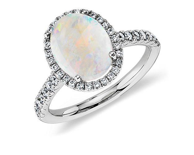 A vision of shimmering colors, this opal and diamond ring features an oval opal framed by forty-four pavé-set round brilliant diamonds in 18k white gold. While perfect for special occasion wear, opals are a softer gemstone and not recommended for daily wear.
