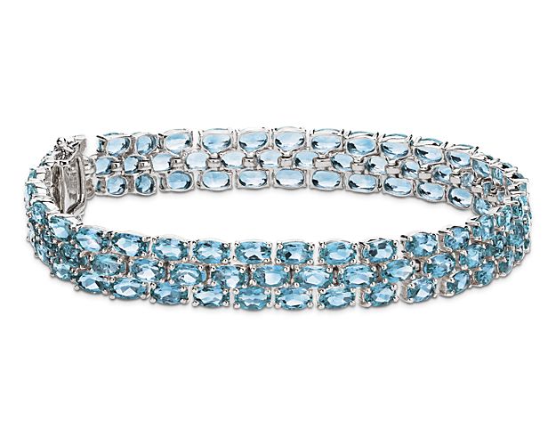 Show your true color with this topaz bracelet crafted in sterling silver  featuring more than 90 oval blue topaz gemstones in a flexible triple line design.