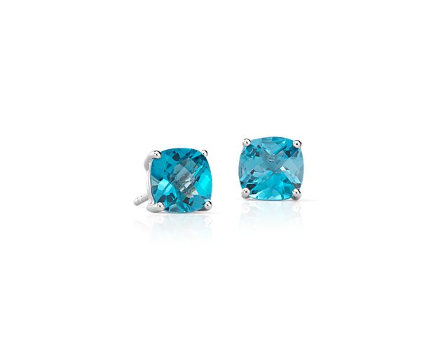 Vibrant Swiss blue topaz gemstones, set in polished four-prong sterling silver stud earrings, add a touch of color to your everyday style. The unique, faceted cushion shape of the gemstones offers a modern twist on the classic solitaire stud.