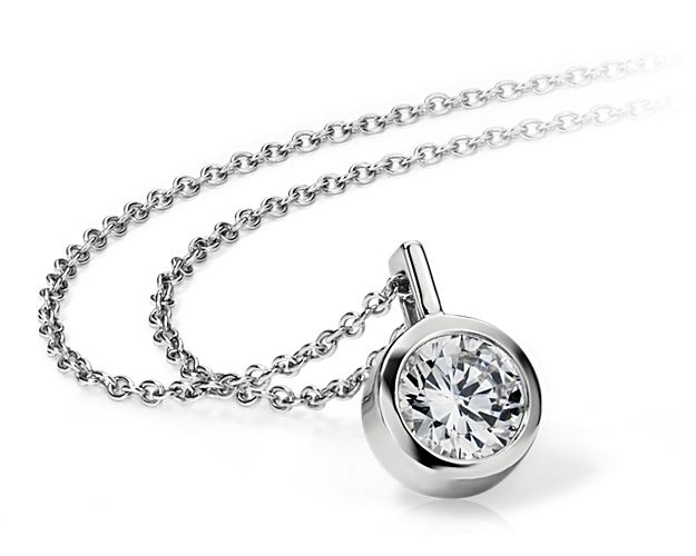 A key piece you'll wear every day, this bezel solitaire pendant setting in polished 14k white gold can be set with your choice of round diamond. It comes suspended from a matching adjustable cable chain 16-18inches in length.
