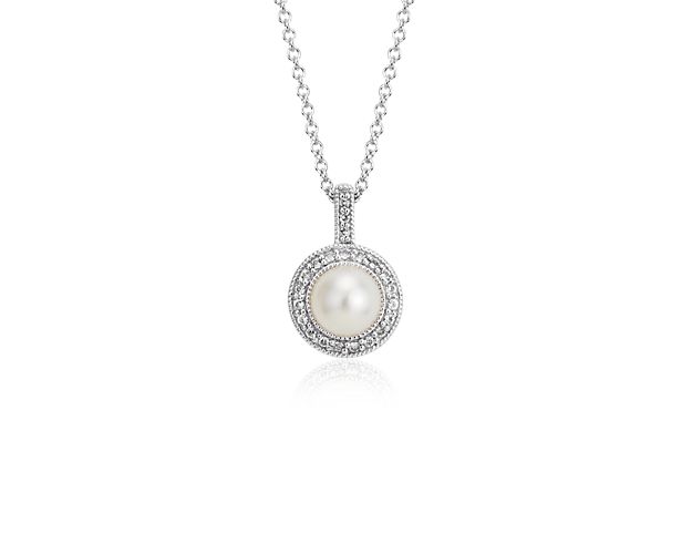 Exemplify refined elegance with this freshwater cultured pearl pendant, showcasing a detailed milgrain halo of white topaz gemstones and a sterling silver frame.