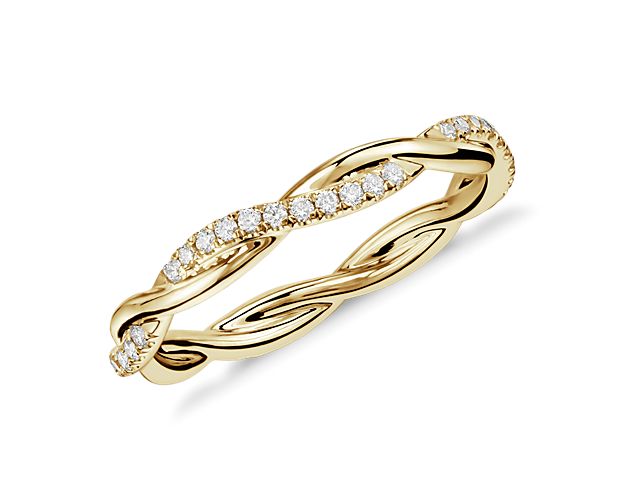 This beautiful and delicate wedding ring is formed by two intertwining bands, one of micropavé set diamonds and one of solid 14k yellow gold for an elegant statement.