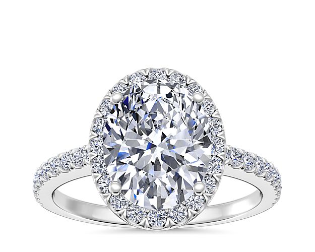 The unique brilliance of this oval-shaped halo diamond engagement ring offers an innovative twist on the classic style. Delicately crafted in enduring platinum, each ring features a single row of micro-pavé set round brilliant-cut diamonds framing the oval-cut center diamond of your choice.
