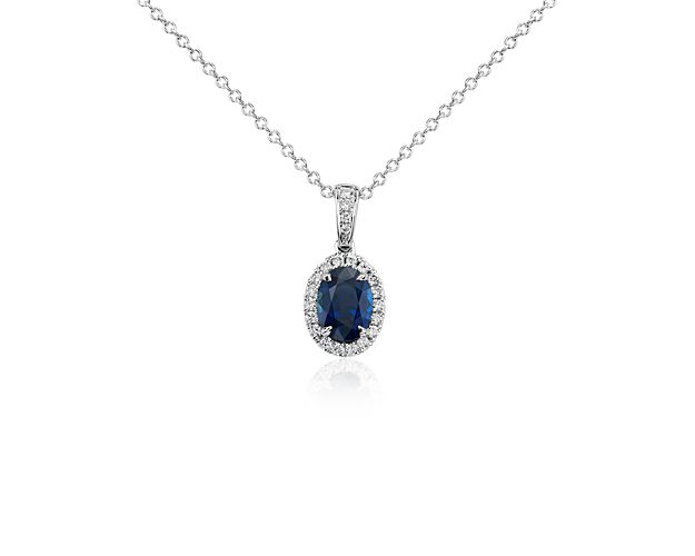 Vintage appeal and vibrant color graces this sapphire gemstone pendant accented by a shimmering halo of diamonds and suspended from a 14k white gold cable chain necklace.