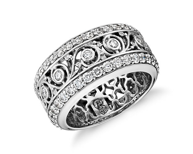 Exquisite decorative detailing makes this significant 18k white gold eternity band a true standout. Two rows of pavé-set diamonds frame even more tiny diamonds set in a distinctive swirling leaf design.