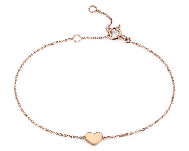 Fall head over heels for this petite heart bracelet. Crafted in blushing 14k rose gold, this sweet little polished heart is stationed along a delicate cable chain that can be adjusted in length for the perfect fit.