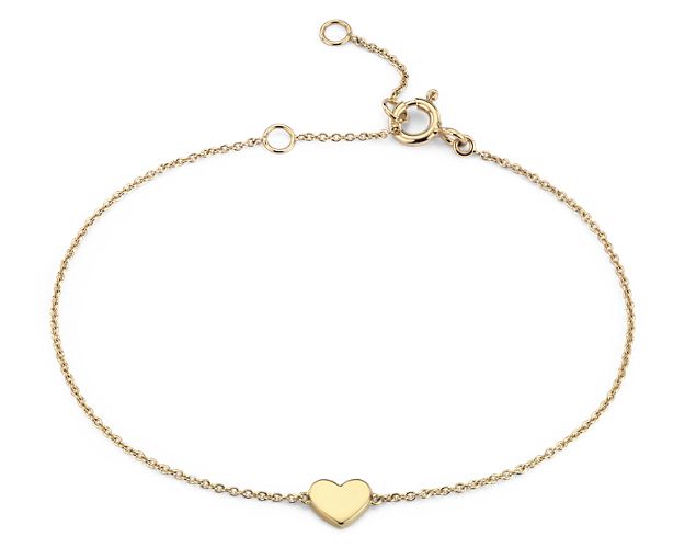 Fall head over heels for this petite heart bracelet. Crafted in glowing 14k yellow gold, this sweet little polished heart is stationed along a delicate cable chain that can be adjusted in length for the perfect fit.