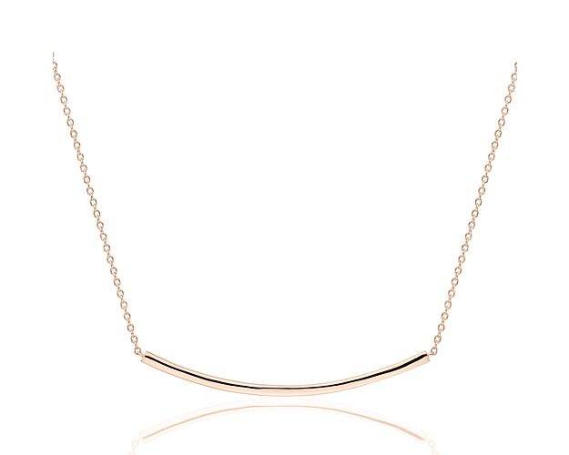 Understated and perfect for everyday style, this delicate curved bar necklace is crafted in 14k rose gold. The slim, polished bar is stationed along a classic cable chain that can be adjusted from 16 to 18 inches in length for versatility and is ideal for layering with other necklaces for an on-trend look.