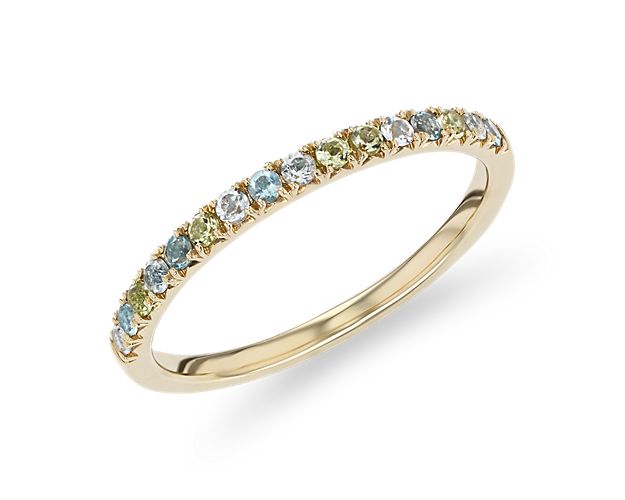 Featuring a row of blue topaz, white topaz, and peridot this 14k yellow gold multi-gemstone ring combines gentle pastel hues with classic glamour.