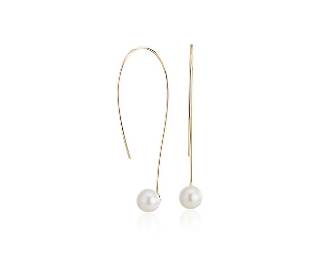 Lustrous Freshwater pearls are showcased at the base of long, curved threaders of 14k yellow gold on these elegant earrings.