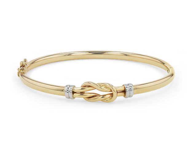 This glamorous 14k yellow gold bangle showcases a classic double-knotted design set off by 14k white gold accents to complete the look.
