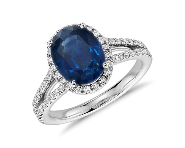 A classic but stylish choice, this elegant sapphire gemstone ring is surrounded by a halo of pavé-set diamonds and showcases a split shank adorned with round diamonds framed in 18k white gold.