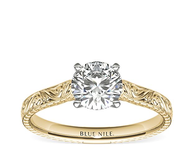 Exquisitely hand-engraved, this engagement ring features an intricate motif to showcase your center diamond in enduring 18K yellow gold.