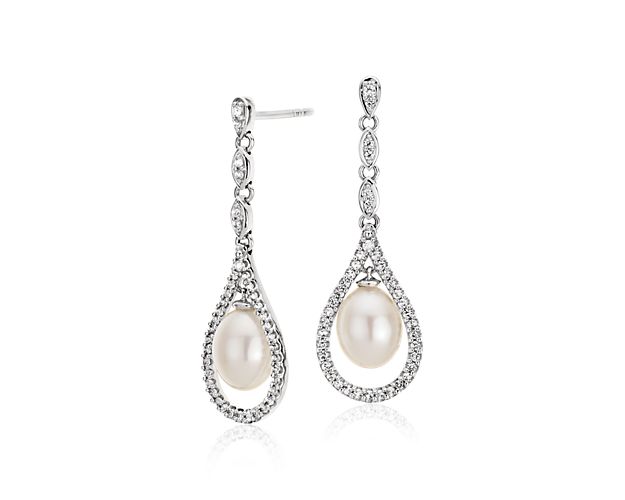 Get just the delicate sparkle you're looking for with these vintage-inspired Freshwater cultured pearl drop earrings. Two stunning white drop pearls are framed by glittering halos of petite white topaz gemstones framed in sterling silver. These gorgeous drop earrings are a beautiful bridal style that works well beyond your big day.