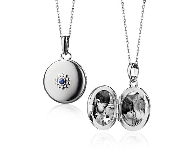 This locket, forged of sterling silver, features a sapphire center stone with a beaded edging and hangs off a 17 inch chain. A perfect piece to hold memories close to your heart, Monica Rich Kosann is known for recreating the classic locket into a jewelry piece that can hold your own unique stories. Photos or notes easily slide in from the top edge of the locket.