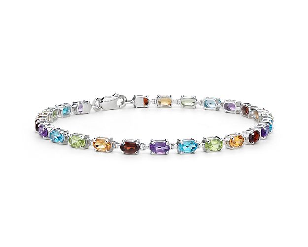 Truly bright and festive, this gemstone bracelet features blue topaz, citrine, amethyst, peridot, and garnet gemstones framed in sterling silver.