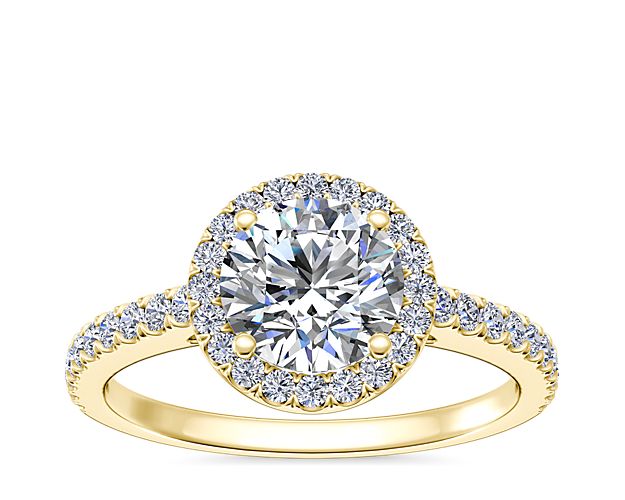 Made to order, create a breathtaking moment with this decadent engagement ring, showcasing a diamond laden shank and halo, deftly framed against immaculate 14k yellow gold.