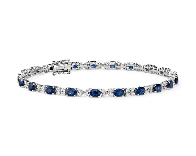 This sapphire and diamond bracelet combines classic tennis bracelet style with a colorful blue hue. Deep blue oval-cut sapphires alternate with round-brilliant cut diamonds in a floral inspired pattern that adds eye-catching interest to this jewelry box essential.