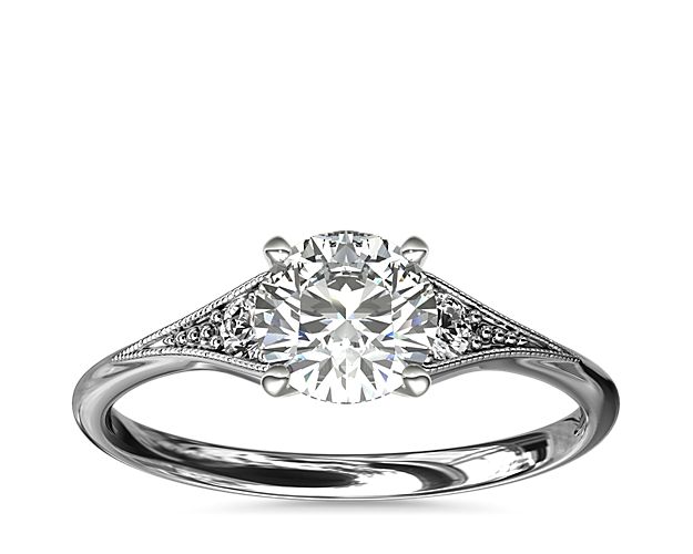 Vintage-inspired, this delicate 14k white gold engagement ring features 2 pavé-set round diamonds surrounded by a milgrain edge.