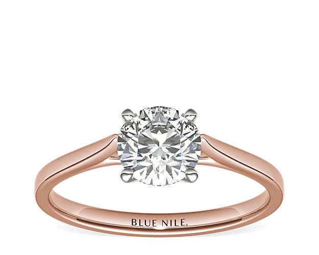 Delicate cathedral shoulders add classic elegance to this petite 14k rose gold solitaire engagement ring setting.
