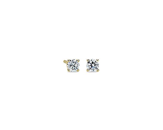 Beautifully matched, these diamond stud earrings feature a pair of round, near-colorless diamonds set in 14k yellow gold four-prong settings with double-notched friction backs.