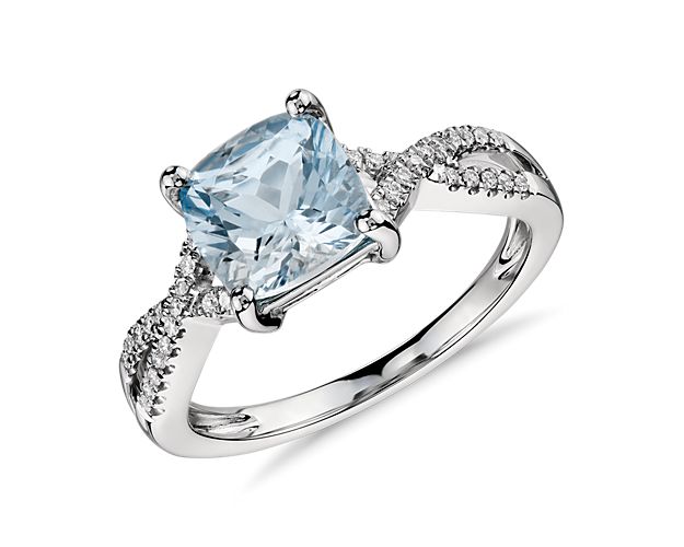 A vision of color, this gemstone ring features a cushion cut aquamarine accented by pavé-set round brilliant diamonds in an infinity twist design of 14k white gold.