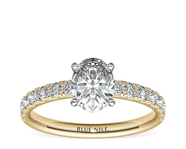 Demure and sparkling, this diamond engagement ring features round diamonds pavé-set in 18k yellow gold to complement your choice of diamond.