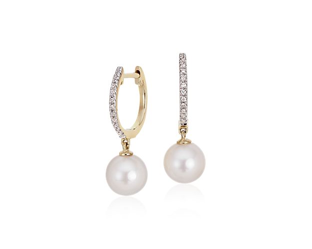 Luminous and sparkling, these Akoya cultured pearl and diamond hoop earrings are a perfect day-to-night pair. Two round white pearls are suspended from petite, pavé diamond hoops with a hinged back closure crafted in polished 14k yellow gold.