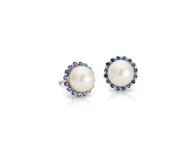 Mid-century style goes modern with these sapphire and Freshwater cultured pearl stud earrings. Two classic white pearls are surrounded by a bevy of petite blue sapphire gemstones creating an irresistibly chic look. A perfect "something blue" for that special day.