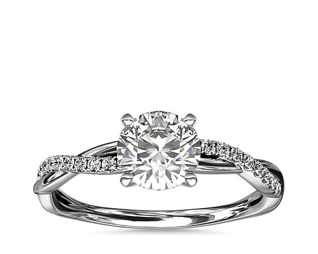Classic with a twist, this platinum engagement ring features a delicate twist of pavé-set diamonds that will complement the center diamond of your choice.