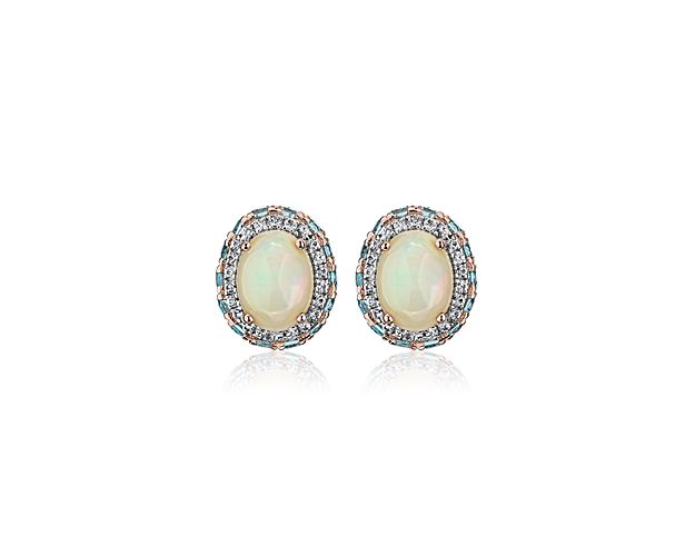 Show off a classic style with these opal gemstone earrings, framed in 14k rose gold and finished off with and elegant blue topaz and white sapphire halo.