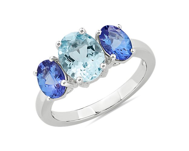 An interplay of ocean blue hues brings calming beauty to this 14k white gold ring as two oval-cut tanzanite stones sit nestled on either side of a brilliant oval-cut aquamarine.
