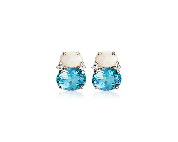 Decadent in color, these gemstone stud earrings feature vivid blue topaz and iridescent opals set in 14k yellow gold, with petite white sapphire accents for added sparkle.