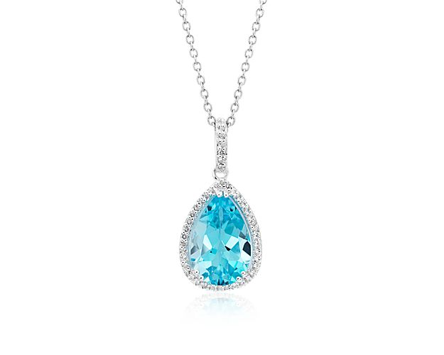 A soft sky blue topaz gemstone adds a pop of color to this timeless drop pendant. A subtle but sparkling halo of transparent white topaz adds a refined finish.