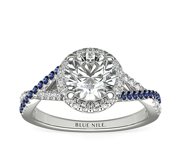 A twist of brilliance and a touch of blue will give elegant sparkle to your proposal. Diamonds and sapphires undulate and surround your center stone, crisscrossing along the white gold band in a gorgeous display.
