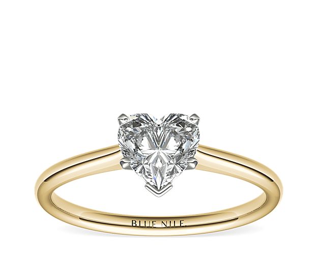 A simple band of elegant polished yellow gold provides a classic backdrop for your choice of sparkling center diamond.