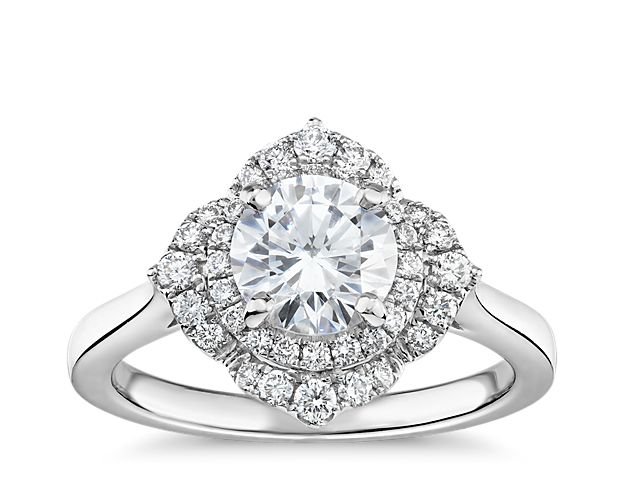 A classic band in 14k white gold presents your choice of center diamond surrounded by a halo of round diamonds. This display, in turn, is surrounded by more pavé diamonds, for a total of forty round diamonds delivering their brilliant sparkle.