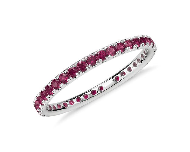 This gemstone eternity ring features a petite row of rubies set in complementary 18k white gold.