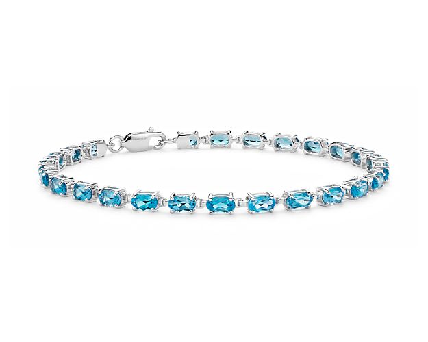 Truly bright and festive, this gemstone bracelet features vibrant Swiss blue topaz gemstones framed in a delicate sterling silver setting.