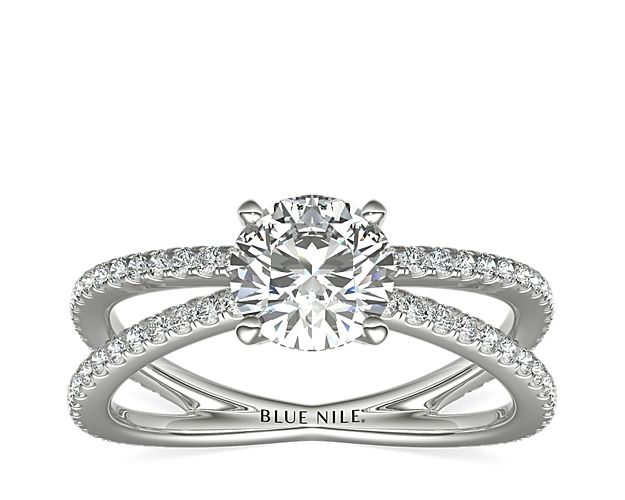 Beautifully crafted, this platinum engagement ring features two diamond bands that form a reverse split shank (a band that splits on the sides of the ring rather than at the front like a traditional split shank).