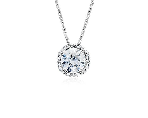 This brilliant diamond pendant showcases a circle of sparkling pavé diamonds to frame your choice of center round diamond, set in platinum with a matching adjustable cable chain 16-18inches in length.