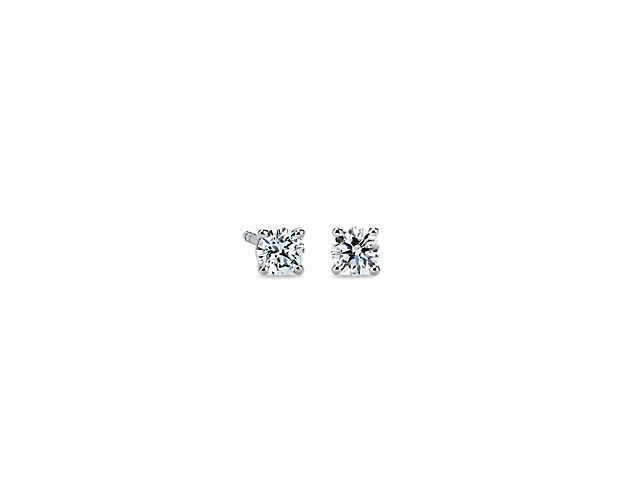 A perfectly matched pair of near-colorless diamonds are secured in platinum four-prong settings with double-notched friction back posts for pierced ears. Each earring weighs roughly 1/4 carat, for a total diamond weight of 1/2 carat.