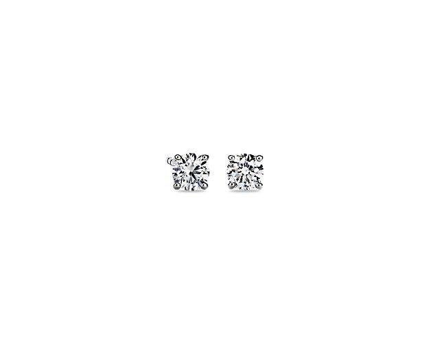 A perfectly matched pair of round, near-colorless diamonds are secured in platinum four-prong settings with double-notched friction posts for pierced ears. Each earring weighs roughly 3/8 carat, for a total diamond weight of 3/4 carat.
