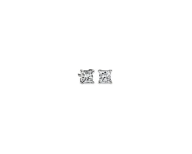 A matched pair of princess-cut diamonds are held by platinum prongs. Earrings are finished with double-notch friction backs for pierced ears. Each earring weighs roughly 1/4 carat, for a total diamond weight of 1/2 carat.